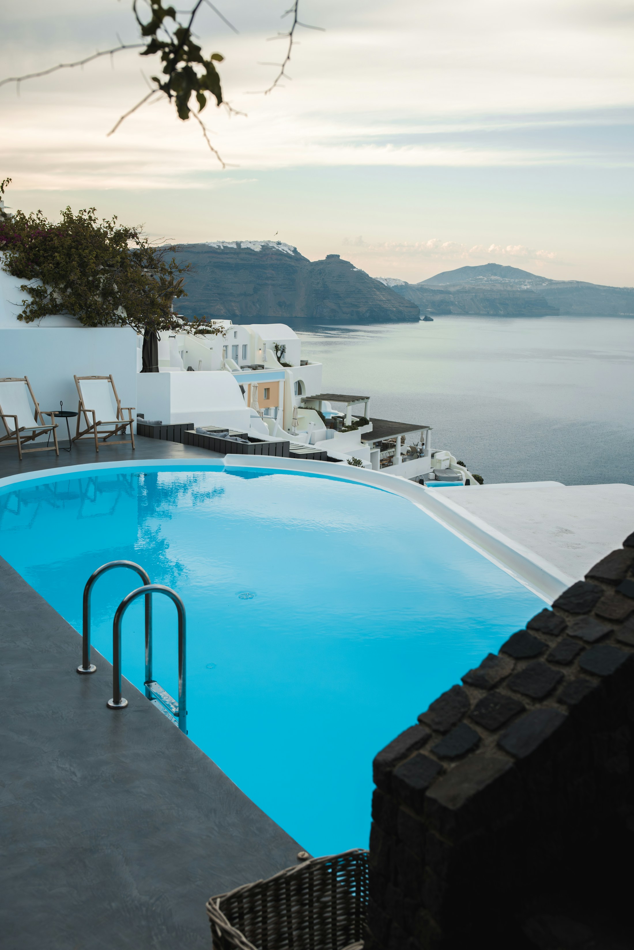 White coastal residences overlooking a quiet sea and infinity pool